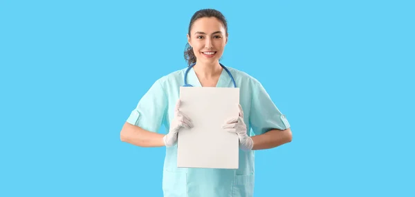 浅蓝色背景空白文件夹的女医疗助理 — 图库照片