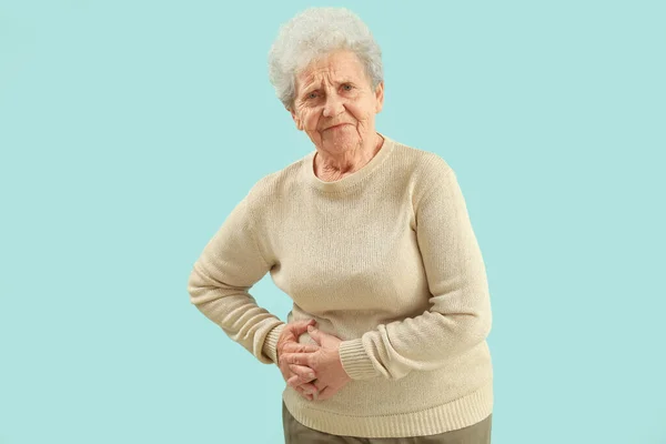 青い背景に虫垂炎を持つシニア女性 — ストック写真
