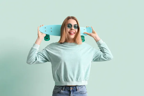 Jonge Vrouw Zonnebril Met Skateboard Groene Achtergrond — Stockfoto