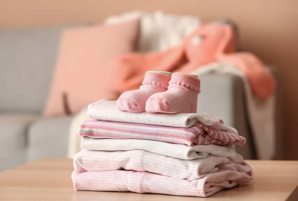 Stapel Babykleidung Und Socken Auf Dem Tisch Zimmer — Stockfoto