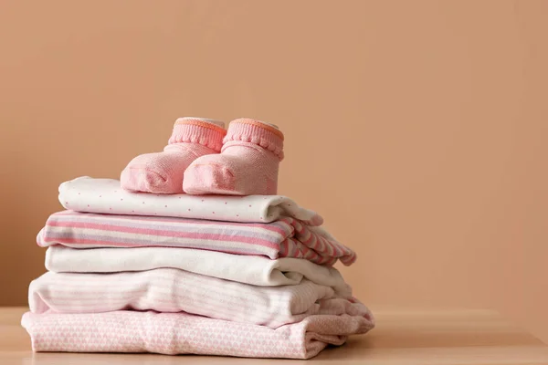 Stapel Babykleidung Und Socken Auf Holztisch Der Nähe Der Wand — Stockfoto
