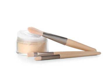 Beyaz arkaplanda toz bulunan makyaj fırçaları