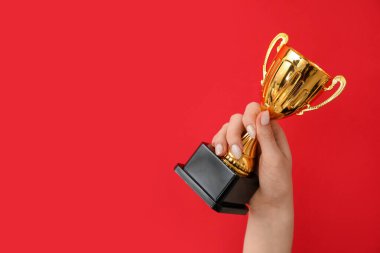 Kırmızı arka planda altın bardaklı kadın