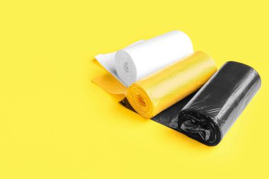 Sarı arka planda farklı çöp torbaları.