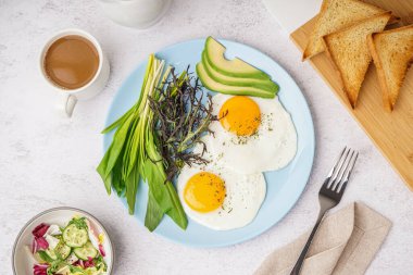 Lezzetli kızarmış yumurta, kahve ve yeşil sebze tabağı.