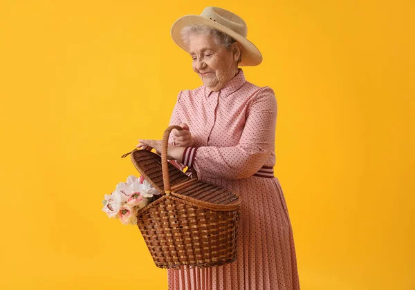 Старшая Женщина Корзиной Цветов Желтом Фоне — стоковое фото
