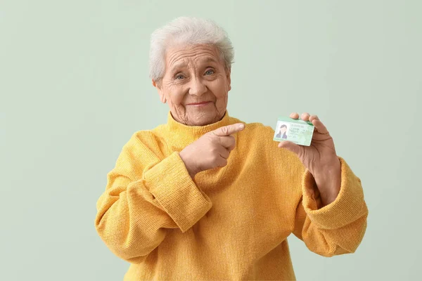 Senior Mulher Apontando Para Carteira Motorista Fundo Verde — Fotografia de Stock