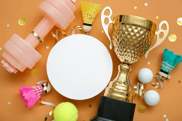 Blank card with gold cup, sports equipment and confetti on orange background