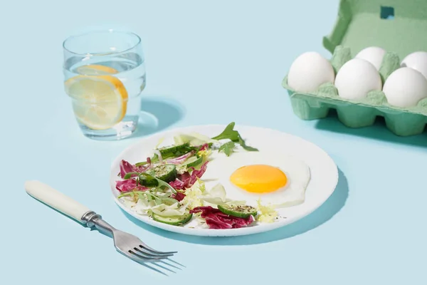 Πιάτο Νόστιμο Τηγανητό Αυγό Και Σαλάτα Μπλε Φόντο — Φωτογραφία Αρχείου