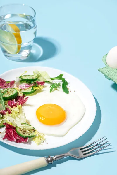 Πιάτο Νόστιμο Τηγανητό Αυγό Και Σαλάτα Μπλε Φόντο — Φωτογραφία Αρχείου