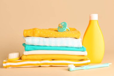 Renkli arka planda bebek kıyafetleri, aksesuarlar ve kozmetik ürünler yığını