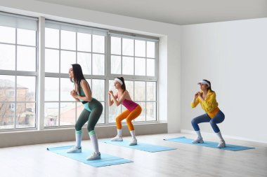 Sportif genç kadınlar spor salonunda aerobik yapıyor.