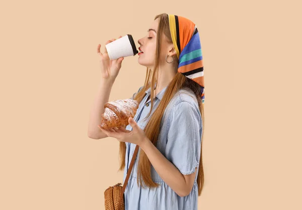 Young Woman Tasty Croissant Drinking Coffee Beige Background — Stock Photo, Image
