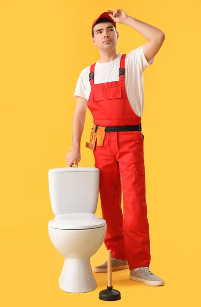 Ung Rörmokare Med Toalett Skål Gul Bakgrund — Stockfoto