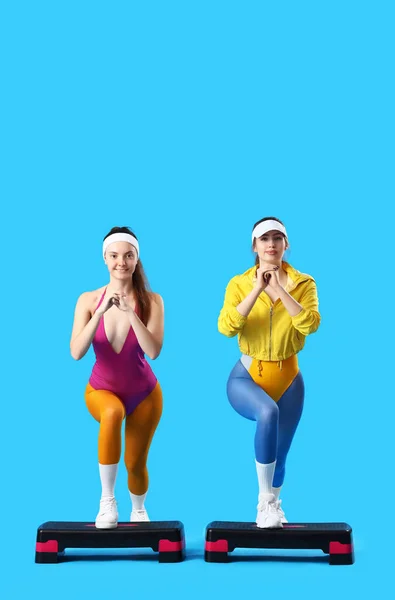 Sportliche Junge Frauen Mit Steppschuhen Beim Aerobic Auf Blauem Hintergrund — Stockfoto