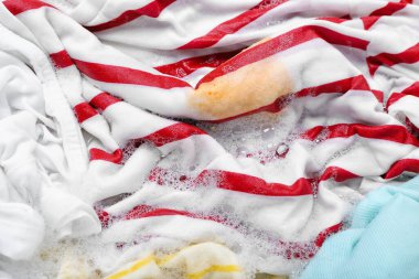 Çamaşır deterjanıyla ıslak kıyafetler, yakın plan.