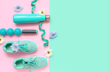 Bahar çiçekli spor ayakkabılar, masaj silindiri ve renkli arka planda mezura.
