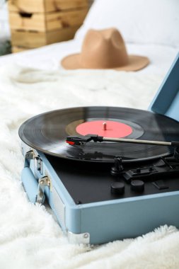 Yatakta vinil diski olan kayıt çalar, yakın plan.