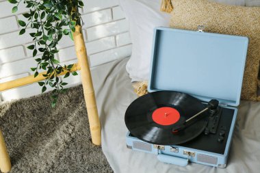 Yatakta vinil diski olan kayıt çalar