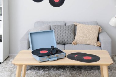 Oturma odasındaki masada vinil disklerle müzik çalar