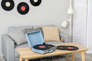 Oturma odasındaki masada vinil disklerle müzik çalar