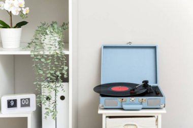 Oturma odasındaki rafta vinil diski olan kayıt çalar