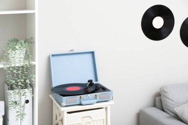Oturma odasındaki rafta vinil diski olan kayıt çalar