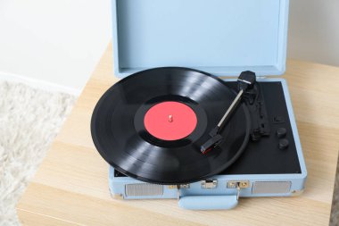 Odadaki ışık duvarının yanındaki masada vinil diskli kayıt çalar, yakın plan.