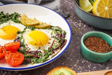 Lezzetli kızarmış yumurta ve gri arka planda salata.