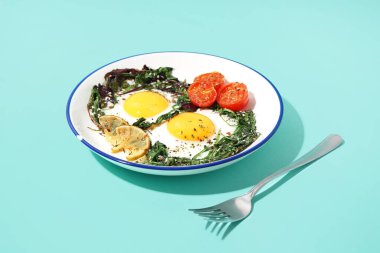 Lezzetli kızarmış yumurta ve mavi arka planda salata.