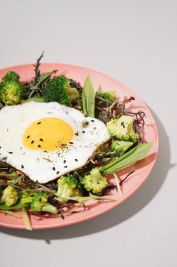 Lezzetli kızarmış yumurta ve gri arka planda salata.