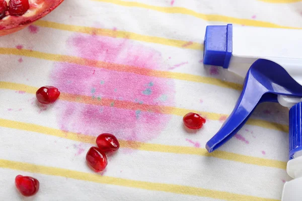 Laundry detergent with pomegranate on stained clothes, closeup