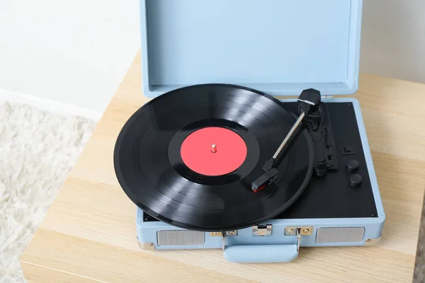 部屋の光壁の近くのテーブルの上にビニールディスクを持つレコードプレーヤー クローズアップ — ストック写真