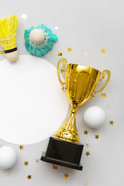 Blank card with gold cup, balls and confetti on light background