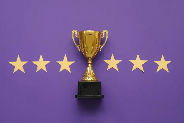 Gold cup with stars on purple background