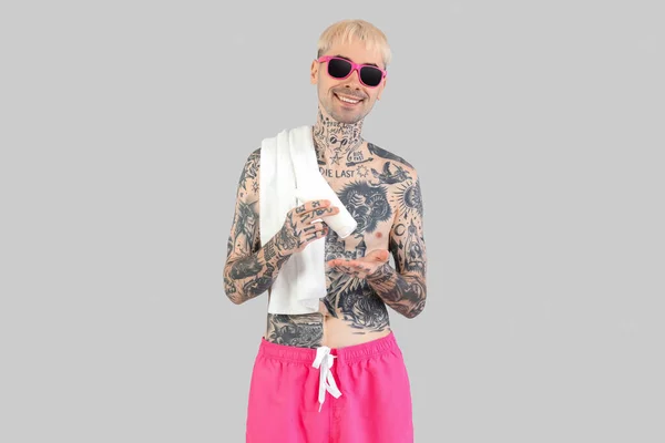 Tattooed Man Applying Sunscreen Cream Light Background — Stock Photo, Image