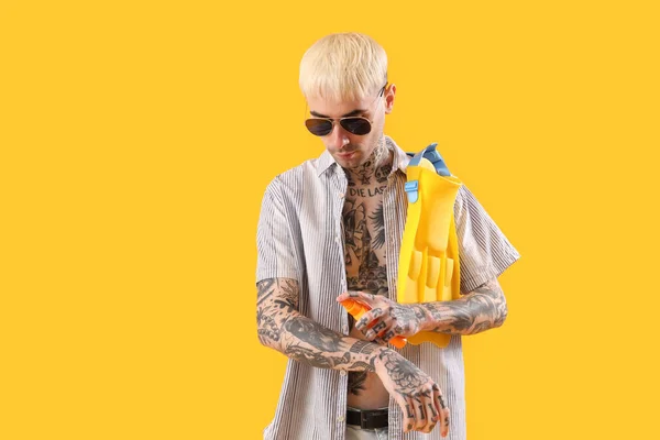 Tattooed Man Applying Sunscreen Cream Yellow Background — Stock Photo, Image