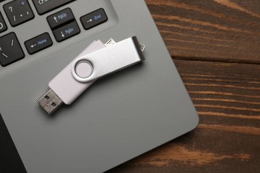 USB flaş bellek ve dizüstü bilgisayar tahta arka planda, yakın plan