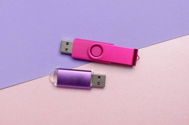 Renk arkaplanındaki renkli USB flash sürücüleri