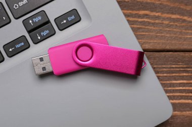 USB flaş bellek ve dizüstü bilgisayar tahta arka planda, yakın plan