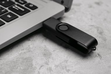Grunge arkaplanında USB flash diski olan dizüstü bilgisayar, kapat