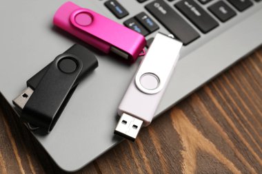 Tahta arka planda USB flaş bellek ve dizüstü bilgisayar, yakın plan