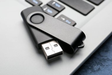 Modern dizüstü bilgisayarda siyah USB flash bellek, yakın plan.