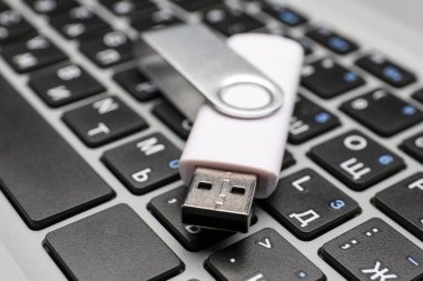 Modern dizüstü bilgisayarda beyaz USB flaş bellek, yakın plan