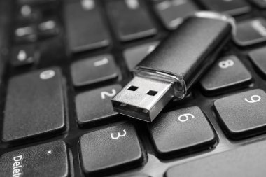 Modern dizüstü bilgisayarda siyah USB flash bellek, yakın plan.