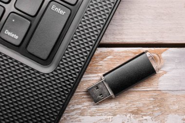 Modern laptop ve siyah USB flaş bellek beyaz tahta arka planda