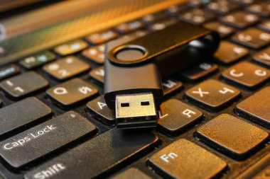 Modern dizüstü bilgisayarda siyah USB flash bellek, yakın plan.