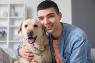 Evinde şirin Labrador köpeği olan genç adam, yakın plan.