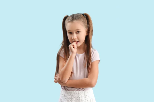 Little Girl Biting Nails Blue Background — 스톡 사진