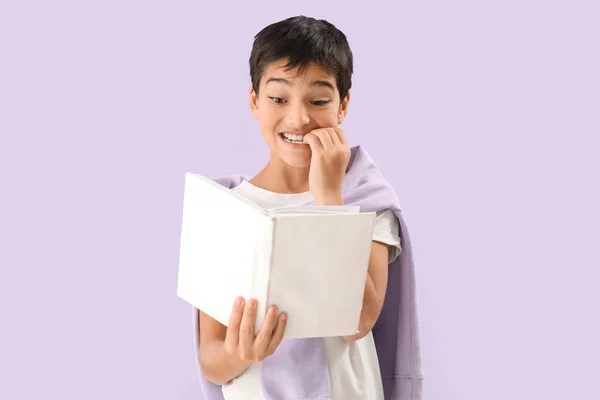 Μικρό Αγόρι Νύχια Που Δαγκώνουν Βιβλίο Λιλά Φόντο — Φωτογραφία Αρχείου